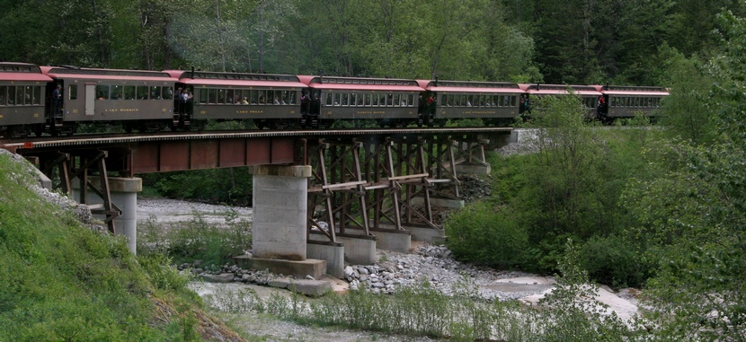 Description: Train crossing bridge over stream. 